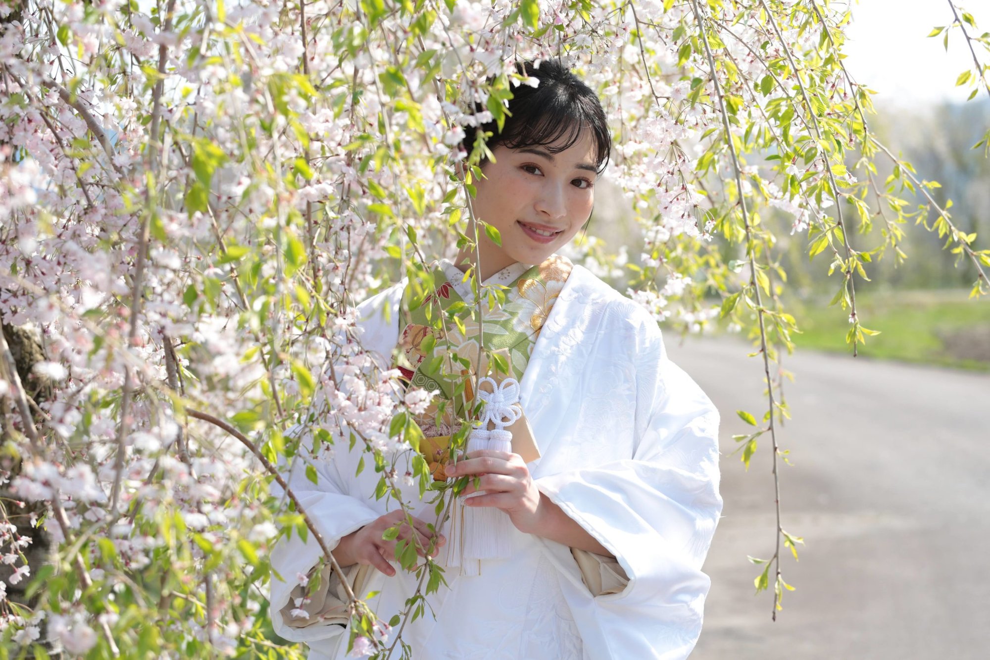 花の下で光に包まれる白無垢の花嫁